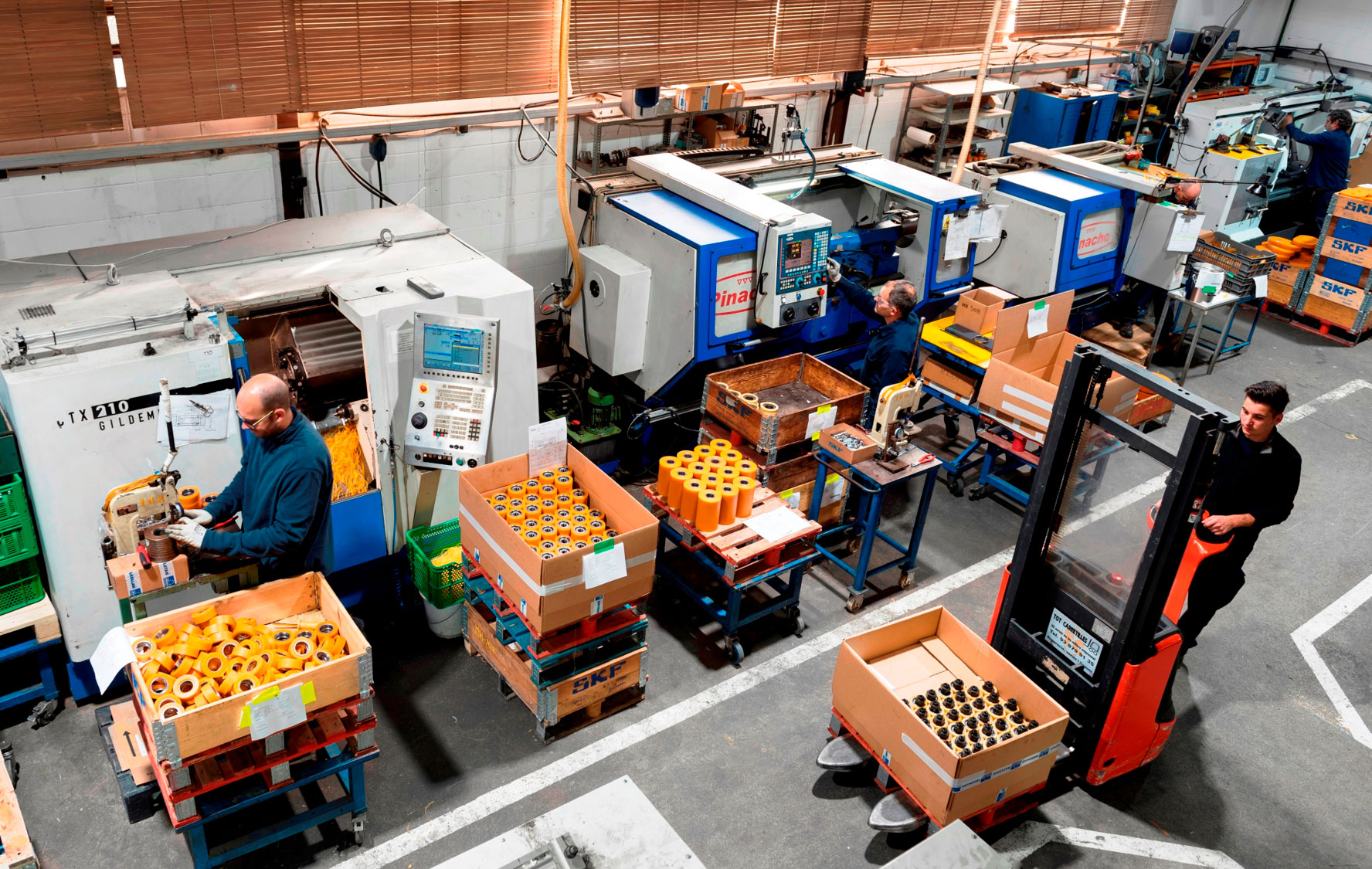 Operarios trabajando en la fabricación de piezas industriales con elastómeros de poliuretano en planta de producción